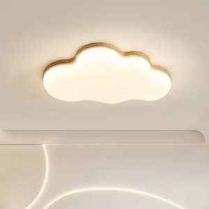 May include: Cloud-shaped ceiling light fixture with a wooden frame. The light has a soft, diffused glow, and the frame is a light brown color. The fixture is mounted on a white ceiling, creating a modern and whimsical aesthetic.