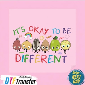May include: A pink graphic featuring the phrase "IT'S OKAY TO BE DIFFERENT" in colorful letters. The design includes cartoon illustrations of various food items with faces, such as a pear, onion, and sunflower seed. A rainbow and other small graphics are also included.