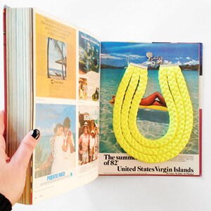 May include: A bright yellow braided necklace on a magazine page with a tropical beach scene and the text "The summer of '82 United States Virgin Islands".
