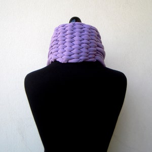 May include: A purple knitted cowl neck scarf on a black mannequin.