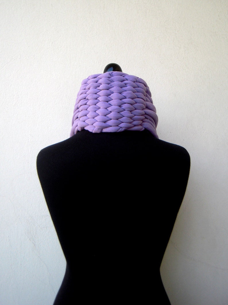 May include: A purple knitted cowl neck scarf on a black mannequin.