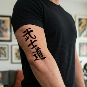 May include: A black short-sleeved t-shirt featuring a temporary tattoo on the upper arm. The tattoo consists of four black Japanese kanji characters arranged vertically, representing the concept of Bushido, written in a bold, calligraphic style.