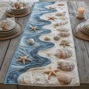May include: A coastal-themed quilted table runner. It showcases a blue wave design, white sand, and an array of seashells and starfish. The runner is displayed on a wooden table, creating a seaside atmosphere.