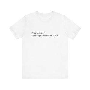 Puede incluir: Camiseta blanca con el texto negro "Programmer Turning Coffee Into Code". La camiseta de cuello redondo está hecha de un material suave. El texto está centrado en la parte delantera de la prenda.