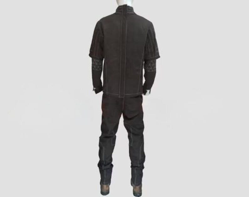 May include: A dark brown two-piece outfit displayed on a mannequin. The outfit includes a jacket with short sleeves and decorative stitching, and matching pants. The sleeves have a patterned design. The outfit is made of a sturdy material.
