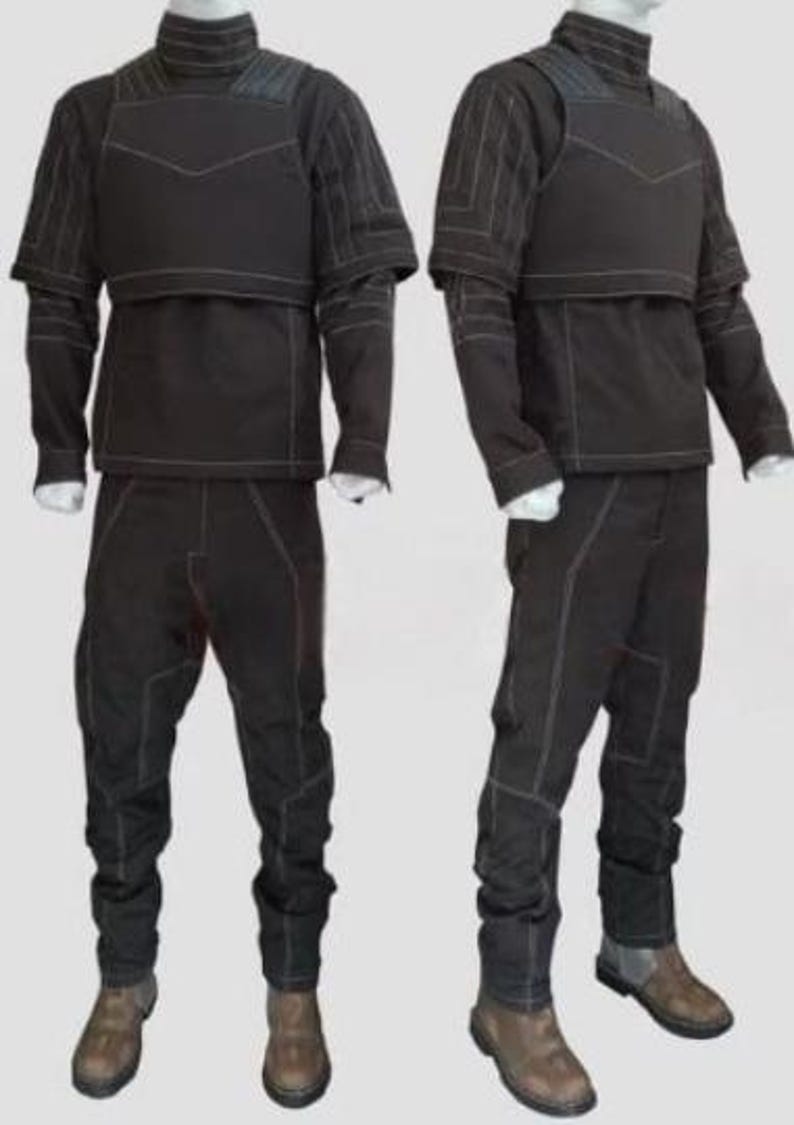 May include: Two black tactical outfits displayed on mannequins. Each outfit includes a high-collared top with a chest protector, long sleeves, and matching pants. White stitching accents the seams. The outfits are paired with brown boots.