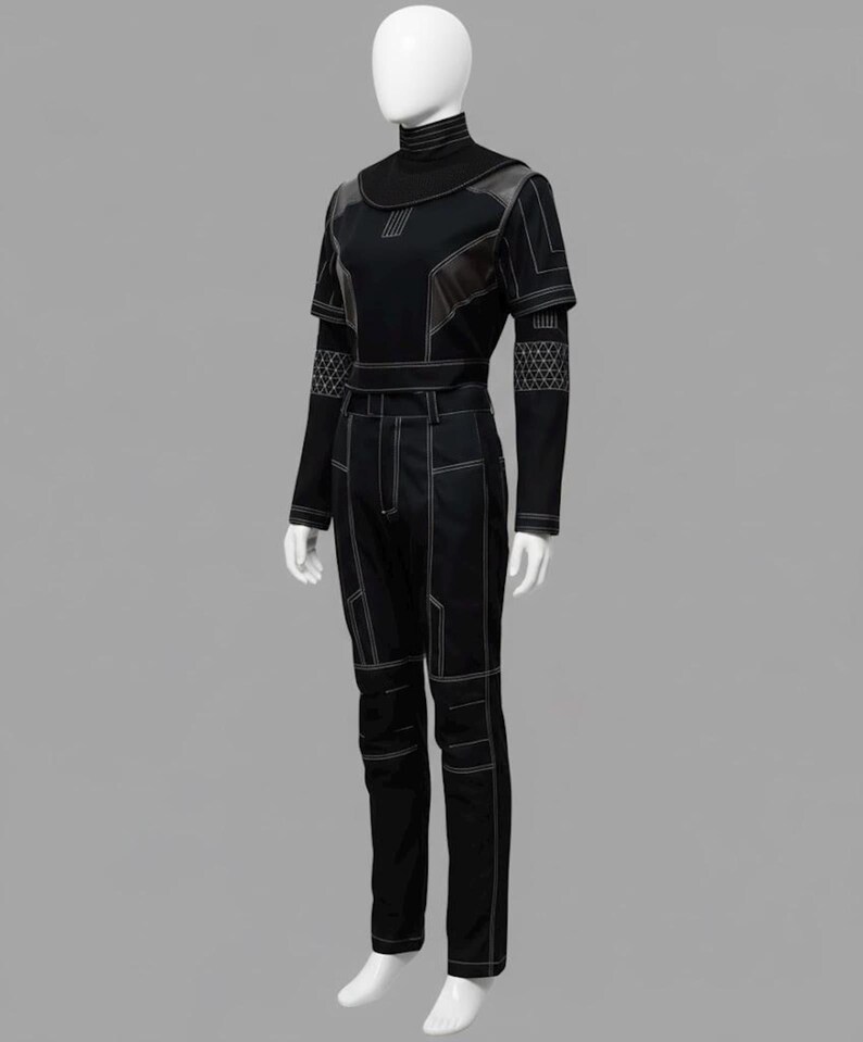 May include: A black two-piece outfit consisting of a short-sleeved top with a high mock neck and long trousers. The ensemble features prominent white contrast stitching, geometric paneling, and intricate grid-patterned details on the sleeves.