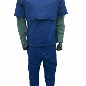 May include: A blue jumpsuit with a short-sleeved top and matching pants. The top has a padded chest and shoulder area with a gray collar. The sleeves are green. The pants have pockets and visible stitching. The outfit is displayed on a mannequin.