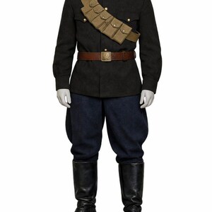 May include: A military uniform on a mannequin. The dark gray jacket has gold buttons, red shoulder boards, and a tan cartridge belt. The uniform includes navy blue pants, a brown belt, and black leather boots.