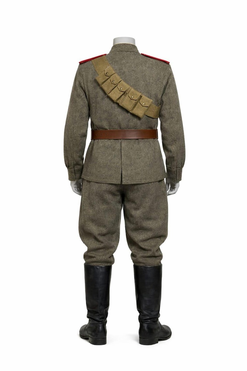 May include: A military uniform on a mannequin. The olive-drab wool uniform includes a jacket with red shoulder boards, matching trousers, a brown leather belt, and black leather boots. A bandolier with pouches is across the chest.