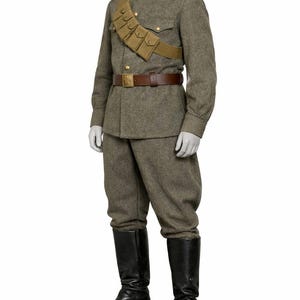 May include: A military uniform consisting of a gray wool jacket and trousers, a brown leather belt, and black leather boots. The jacket has red shoulder boards and a tan cartridge belt. The uniform is displayed on a mannequin.