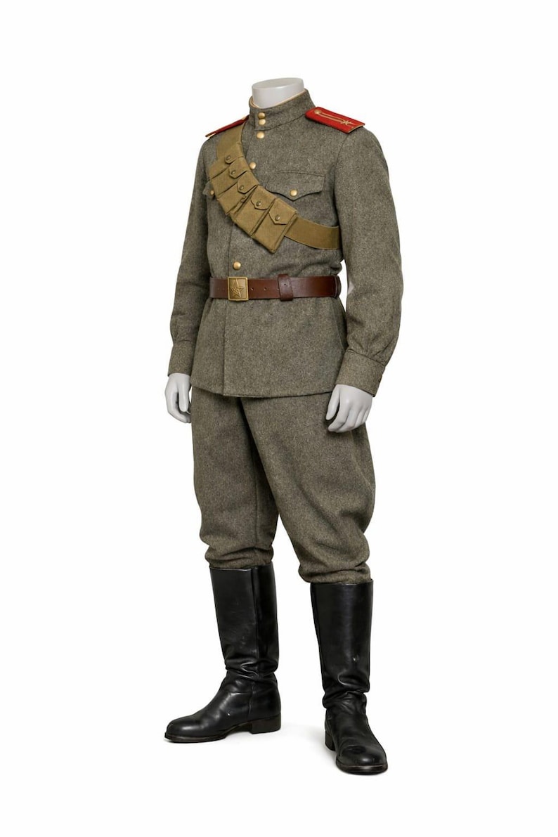 May include: A military uniform consisting of a gray wool jacket and trousers, a brown leather belt, and black leather boots. The jacket has red shoulder boards and a tan cartridge belt. The uniform is displayed on a mannequin.