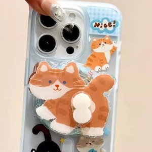 May include: Clear phone case with a blue grid pattern and cartoon cat designs. The case features orange, black, and gray cat illustrations, with the word "Nice!" at the top. The phrase "Sweet Life" is also visible.