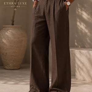 May include: Dark brown trousers with a wide-leg cut, featuring a high waist, front pleats, and side pockets. The trousers are paired with a white long-sleeved shirt and dark brown leather dress shoes. The logo ETHRA LUXE ATTIRE is visible.