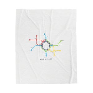 Op de afbeelding: Witte deken met een kleurrijk metrokaartontwerp. De kaart heeft een centraal cirkelvormig station met uitstralende lijnen in rood, blauw, groen en geel. De coördinaten 40.706° N / 73.944° W staan eronder afgedrukt.