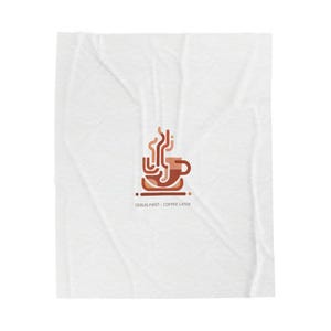 May include: White blanket with a coffee cup graphic in shades of brown. The design includes steam rising from the cup and the text "DEBUG FIRST - COFFEE LATER" at the bottom. The blanket is folded.