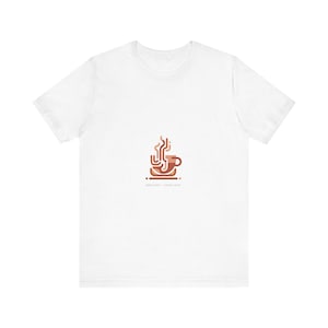 May include: White t-shirt featuring a minimalist coffee cup design in shades of brown, with steam rising from the cup. The text "SERIOUS FIRST - COFFEE LATER" is printed below the graphic. A casual tee for coffee lovers.