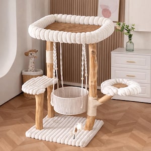 May include: A multi-level cat tree with a natural wood frame and plush, white, cushioned platforms. Features include a hanging basket, a top perch, and a base with a soft, ribbed texture. Includes a small toy.