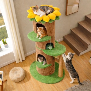 May include: A multi-level cat tree with a sunflower-shaped top, tree trunk design, and green platforms. Three cats are lounging on the tree. One cat is climbing the side. The tree has a natural, textured appearance.