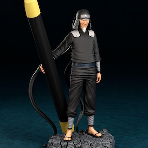 May include: A detailed figurine of Hiruzen, a character from the Naruto series, holding a large black pen with a yellow tip. The figure is dressed in a black outfit and stands on a rocky base. The name "HIRUZEN" is inscribed on the base.