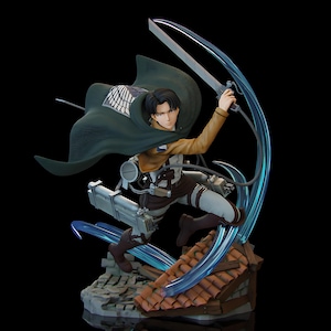 Puede incluir: Figura detallada de un personaje de la serie de anime Attack on Titan. La figura está posada dinámicamente con una espada y una capa verde. La base es un tejado en miniatura.