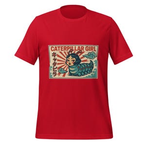 May include: Red t-shirt featuring a graphic of a woman as a caterpillar with the text "CATERPILLAR GIRL" and Japanese characters. The illustration has a vintage aesthetic with a blue, green, and red color palette.