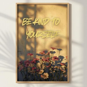 Puede incluir: Una impresión enmarcada con las palabras "BE KIND TO YOURSELF" en escritura amarilla. El fondo es una superficie texturizada de color amarillo claro con una sombra de hojas. Flores rosas y amarillas en la parte inferior del marco.
