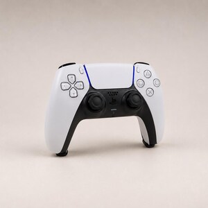 Op de afbeelding: Een wit en zwart draadloze videogamecontroller met een centraal touchpad, twee zwarte analoge sticks, een richtingspad en vier actieknoppen gemarkeerd met driehoek-, cirkel-, kruis- en vierkantsymbolen, voorzien van blauwe lichtaccenten.