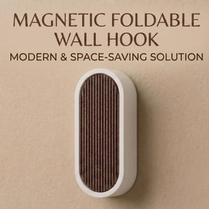 Op de afbeelding: Een witte, ovale magnetische wandhaak met een bruin, verticaal gestreept middenstuk. De tekst "MAGNETIC FOLDABLE WALL HOOK" en "MODERN & SPACE-SAVING SOLUTION" staan boven de haak.