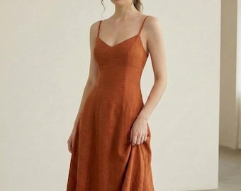 Vestido midi de lino con escote en V, tirantes finos, espalda descubierta, corte en A, sin mangas, ideal para el verano. Color óxido/terracota.