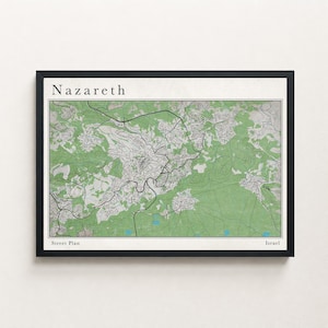 May include: A framed street plan map of Nazareth, Israel. The map features a green and white topographical design with roads and the city name at the top. The words "Street Plan" and "Israel" are at the bottom.