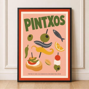 May include: A framed art print with the word "PINTXOS" in green, depicting tapas-style food illustrations like olives, peppers, and a fish. The print has a salmon-pink background and a black frame with a red border.