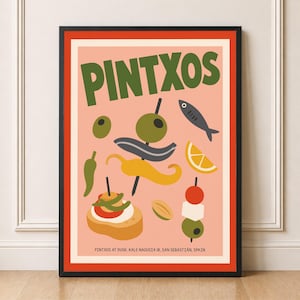 May include: A framed art print with the word "PINTXOS" in green. The print has a salmon-pink background with illustrations of olives, peppers, and tapas. The text "PINTXOS AT DUSK, KALE NAGUSIA 18, SAN SEBASTIAN, SPAIN" is at the bottom.
