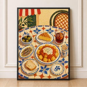 May include: A framed print depicting a table laden with Spanish tapas. The table features a blue and white patterned tablecloth. Dishes include olives, anchovies, a potato dish, bread, and tortilla. A glass of red liquid and a toothpick holder are also present.