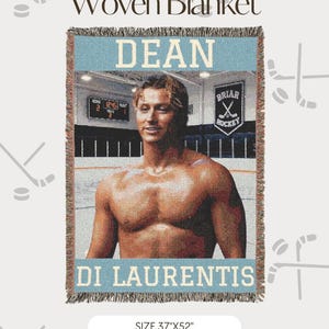 May include: A woven blanket measuring 37 inches by 52 inches featuring a portrait of a shirtless person in a hockey arena. The text DEAN and DI LAURENTIS appear in light blue, with a scoreboard and a Briar Hockey banner in the background.