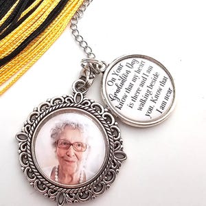 Könnte beinhalten: Ein schwarzer und goldener Abschluss-Quaste mit einem silbernen Anhänger. Der Anhänger hat ein Foto einer Frau und eine Botschaft, die lautet "On Your Graduation Day know that my heart is there and I am walking beside you. Know that I am near."