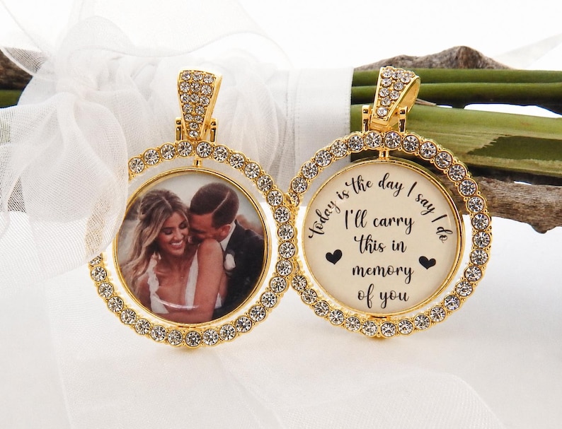 May include: Two gold-toned circular pendants framed with clear crystals. One pendant displays a photograph of a couple, while the other features the black text: Today is the day I say I do, I'll carry this in memory of you, with two small hearts.