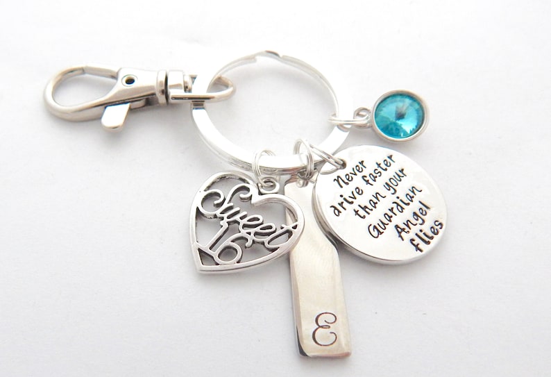 Puede incluir: Llavero de plata con un dije en forma de coraz&oacute;n que dice "Sweet 16", un dije de plata con el texto "Nunca conduzcas m&aacute;s r&aacute;pido que tu &aacute;ngel de la guarda vuela", un dije de plata con la letra "E" y un dije de cristal azul claro.