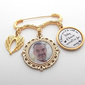 May include: Gold tone memorial brooch with a photo charm, a charm with angel wings, and a charm with the text "I knew you'd be with me today if heaven weren't so far away".