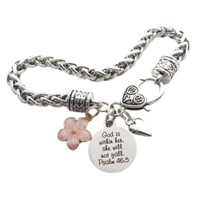 Puede incluir: Pulsera de cadena plateada con un dije de coraz&oacute;n, un dije de flor y un dije redondo con el texto "Dios est&aacute; en ella, no caer&aacute;. Salmo 46:5".