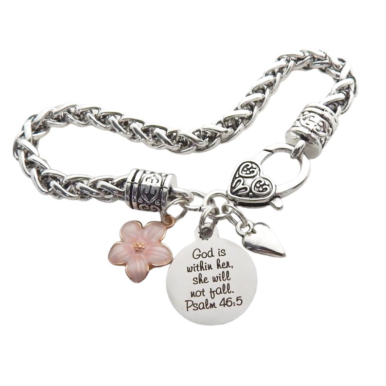 Puede incluir: Pulsera de cadena plateada con un dije de coraz&oacute;n, un dije de flor y un dije redondo con el texto "Dios est&aacute; en ella, no caer&aacute;. Salmo 46:5".