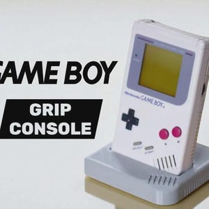 Peut inclure: Une console de jeu Game Boy blanche dans une console de prise grise. Le Game Boy a un écran jaune, une croix directionnelle noire et des boutons roses. Les mots "GAME BOY" et "GRIP CONSOLE" sont en texte noir.
