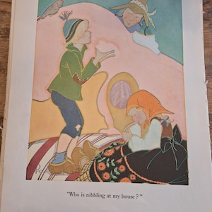 Könnte beinhalten: Vintage Illustration aus einem Kinderbuch. Das Bild zeigt eine junge Person in einer grünen Jacke und blauer Mütze, die auf eine Figur mit Hut zeigt. Eine zweite Person mit orangefarbener Kopfbedeckung sitzt. Der Text lautet: „Wer knabbert an meinem Haus?“