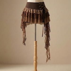 Asymmetrischer Fairycore Rock, Brauner Tiered Lace Minirock, Korsett Taille Rüschenrock, Y2K Boho Festival Kleidung, Steampunk Piratenrock