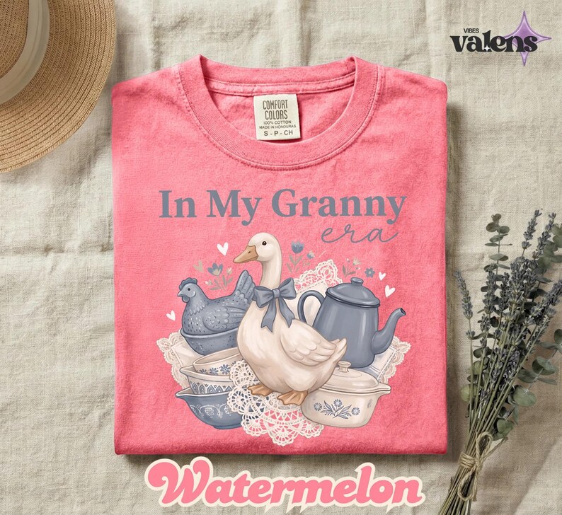 May include: A pink t-shirt with the text "In My Granny era" and a graphic of a goose, chicken, teapot, and bowls. The word "Watermelon" is at the bottom. The shirt is a Comfort Colors brand.