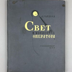 May include: A vintage book with a dark grey cover featuring yellow text and a graphic. The title, "Свет в искусстве оператора," is prominently displayed. The book also includes the text "А. ГОЛОВНЯ" and "ГОСКИНОИЗДАТ 1945."