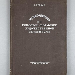 May include: A vintage brown book with the title in Russian: "Guide to Plaster Molding of Artistic Sculpture." The cover features white text and a decorative circular design. The book's title is in the center, with the author's name at the top.