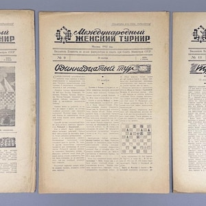 Könnte beinhalten: Drei alte Zeitungen mit russischem Text, die den Titel "Internationales Frauenturnier" in fetter Schrift tragen. Die Zeitungen sind abgenutzt, mit sichtbaren Gebrauchsspuren, und enthalten Schwarz-Weiß-Fotografien und Schachdiagramme.