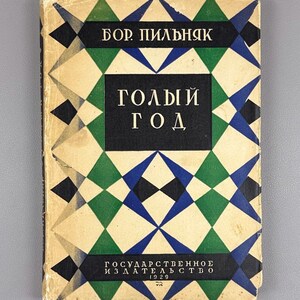 May include: Vintage book titled "Naked Year" in Russian. The cover features a geometric pattern of green, blue, black, and cream diamonds and triangles. The author's name, "Bor Pilnyak," is at the top. The publisher and the year 1929 are at the bottom.