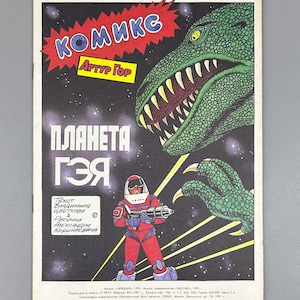 May include: A vintage comic book cover with a green dinosaur and a spaceman with a ray gun. The title "KOMIKC" is in red, and the title "PLANETA GZYA" is in white. The artwork is set against a starry background.